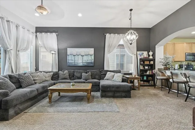 a living room with furniture chandelier and fireplace