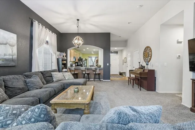 a living room with furniture and a chandelier