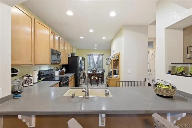 a view of kitchen with kitchen island stainless steel appliances sink stove and refrigerator