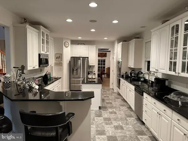 a large kitchen with stainless steel appliances lots of counter space and a sink