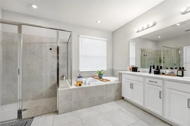 a large bathroom with a double vanity sink a mirror and a shower