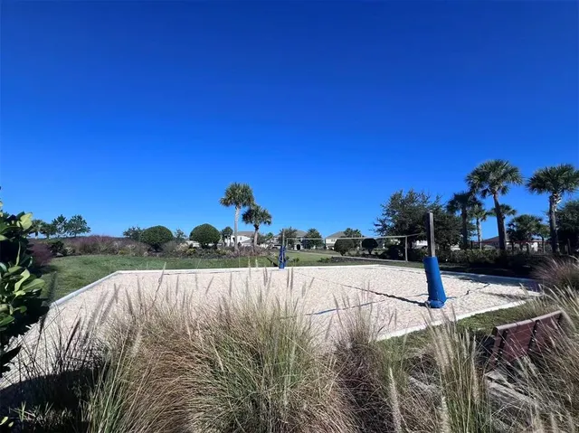 a view of a house with a yard and large trees