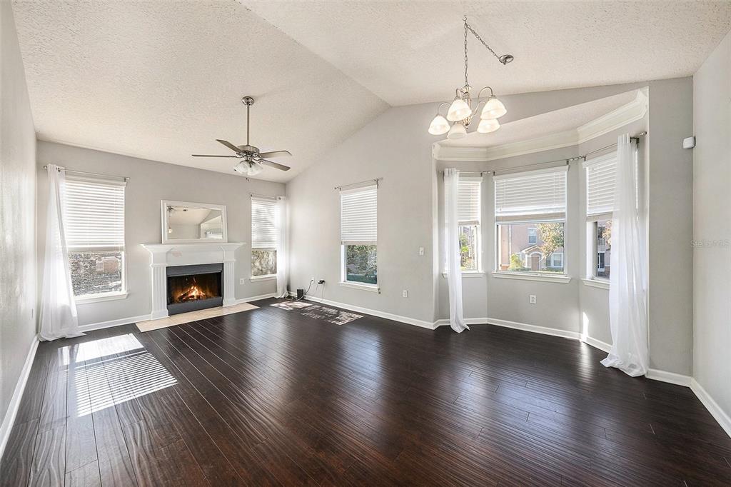 10436 Villa View Circle Tampa, FL 33647 - Photo 4 of 18 an empty room with wooden floor fireplace and windows