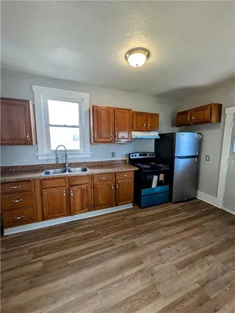 a kitchen with stainless steel appliances wooden cabinets a sink and a stove