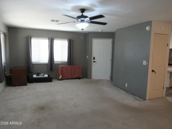 an empty room with windows and a ceiling fan