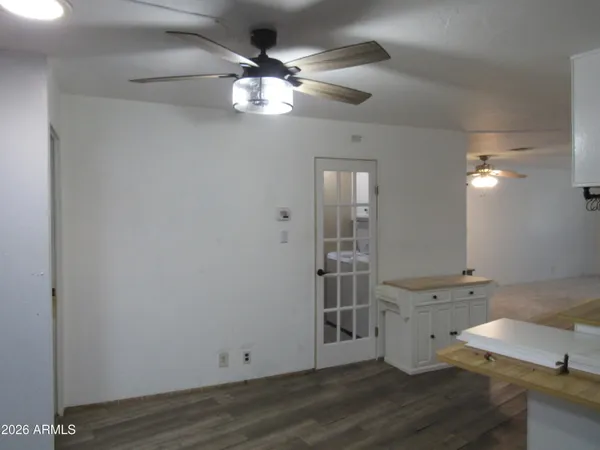 a view of a room with wooden floor and chandelier fan