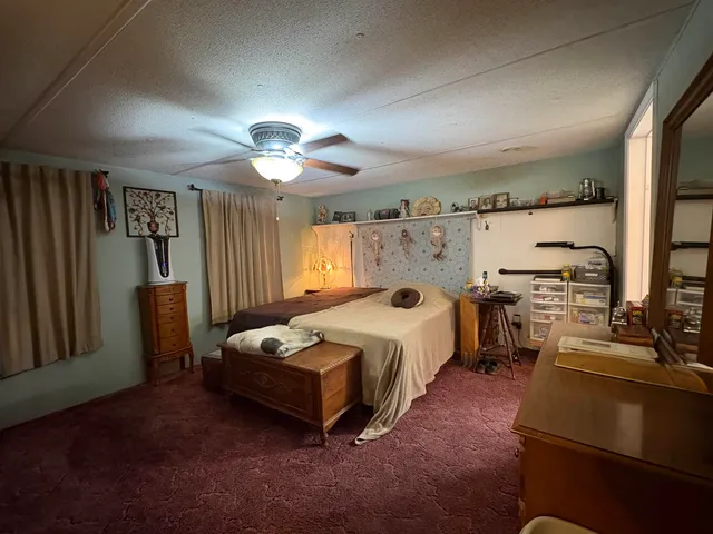 a bedroom with a bed dresser and wooden floor