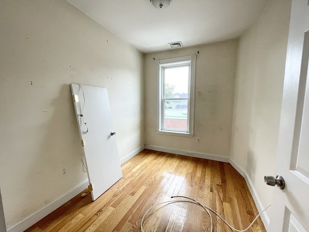 98 L Street, Unit STREET Boston, MA 02127 - Photo 11 of 19 a view of an empty room with wooden floor and a window