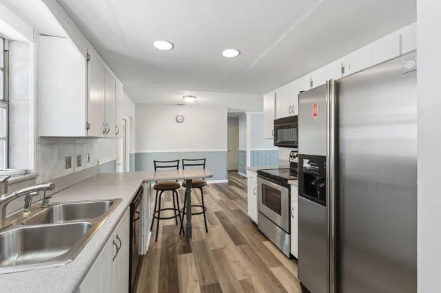 a kitchen with stainless steel appliances granite countertop a refrigerator and a sink
