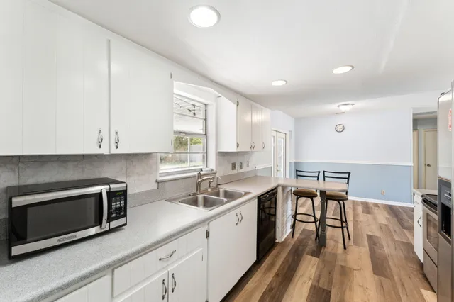 a kitchen with a sink microwave and cabinets