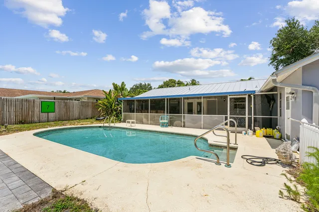 a house view with swimming pool and glass windows