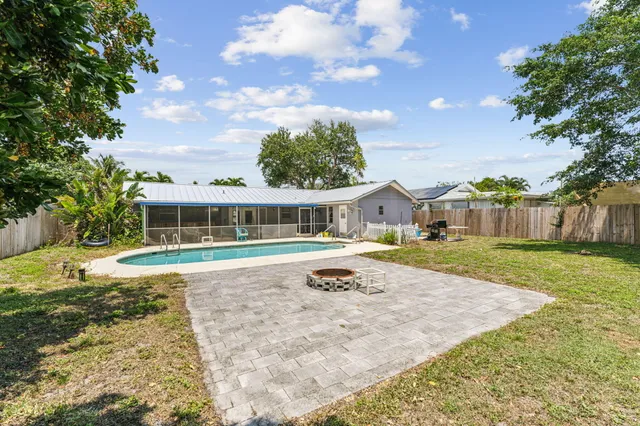 a view of house with yard and swimming pool