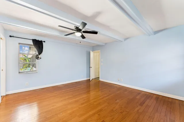 a view of room with wooden floor and ceiling fan