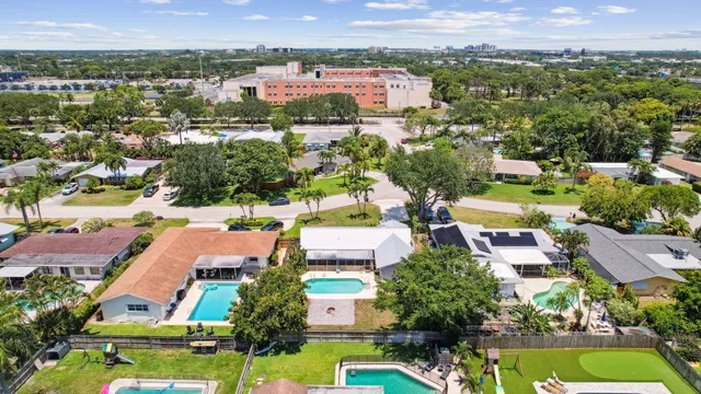 an aerial view of residential houses with outdoor space and swimming pool