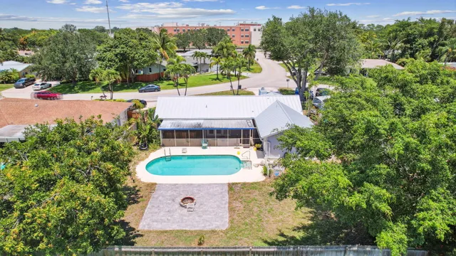 an aerial view of a house with yard and swimming pool
