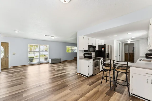 a view of a kitchen with furniture and wooden floor