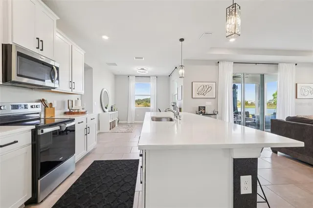a living room with kitchen island stainless steel appliances furniture a stove and a kitchen view