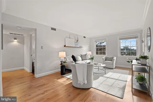 a living room with furniture large window and wooden floor