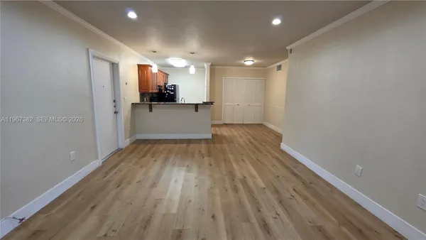 a view of a kitchen with a fridge and wooden floor