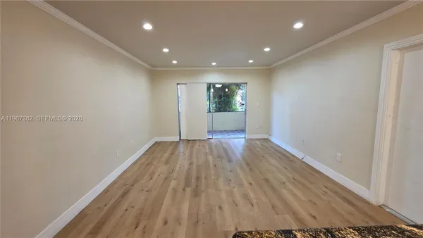 a view of empty room with wooden floor