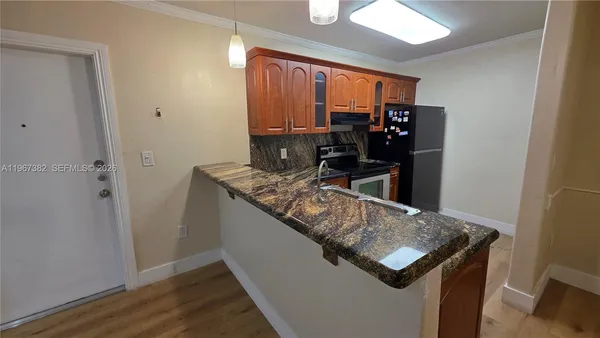 a kitchen with stainless steel appliances granite countertop a sink and a refrigerator