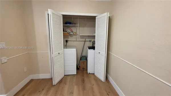 a view of a hallway with wooden floor and closet