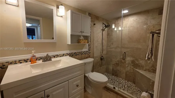 a bathroom with a sink a toilet and shower