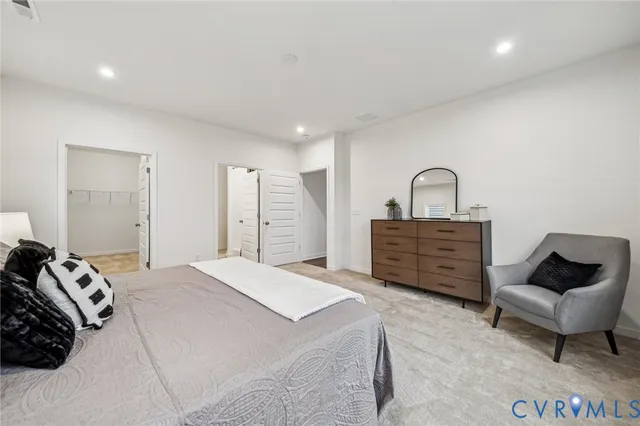 a spacious bedroom with a bed a couch and dresser