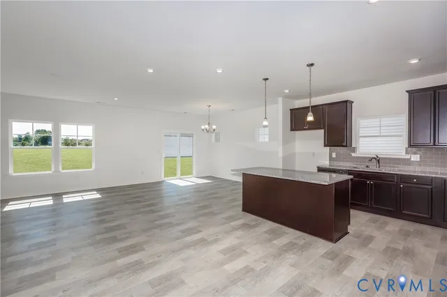 a large kitchen with kitchen island granite countertop a sink a counter top space and stainless steel appliances