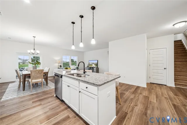 a kitchen with a sink and wooden floor
