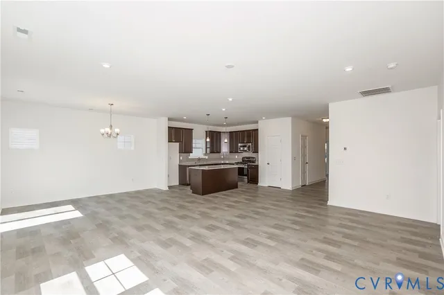 a view of a kitchen with a sink and dishwasher a refrigerator with wooden floor