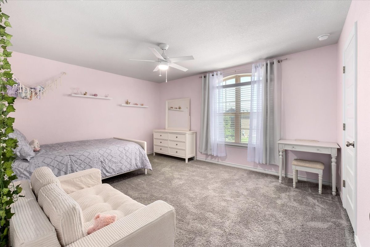 5408 Vanner Path Georgetown, TX 78626 - Photo 24 of 34 Spacious room featuring plush gray carpeting, a ceiling fan with integrated lighting, and an arched window with blinds
