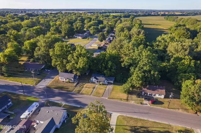 an aerial view of a house with swimming pool garden and patio