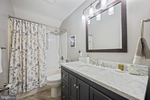 a bathroom with a granite countertop sink a toilet and a mirror