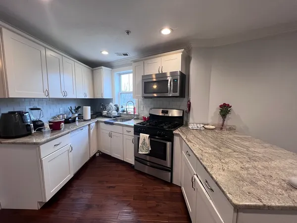 a kitchen with a stove top oven and white cabinets