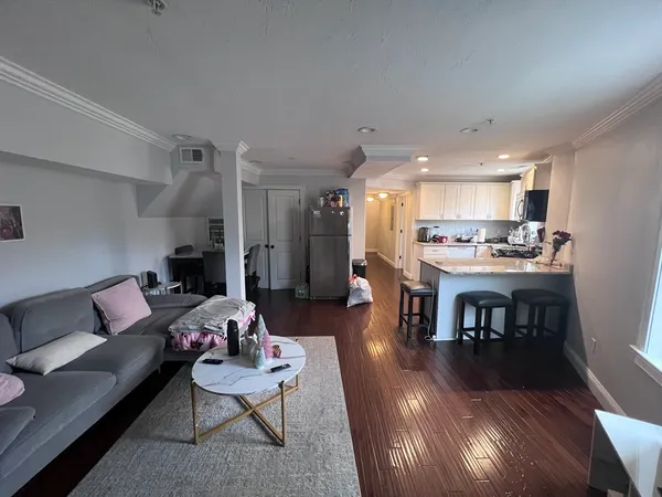 a living room with furniture and kitchen view