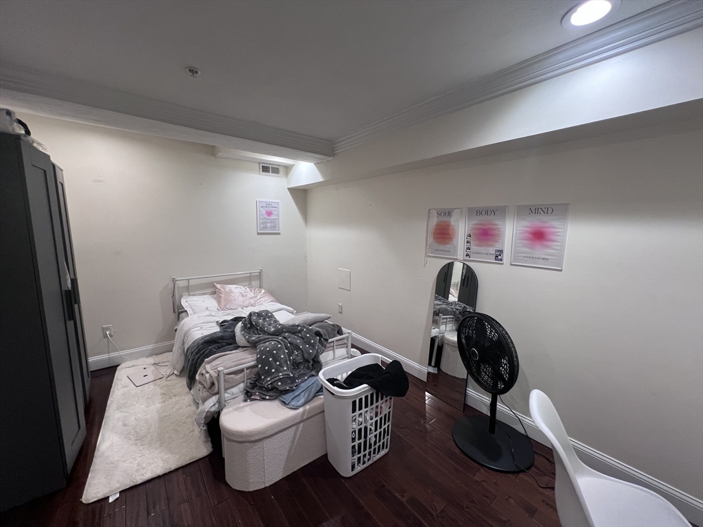 142 Centre Street, Unit 2 Boston, MA 02119 - Photo 4 of 9 a workspace with furniture and wooden floor