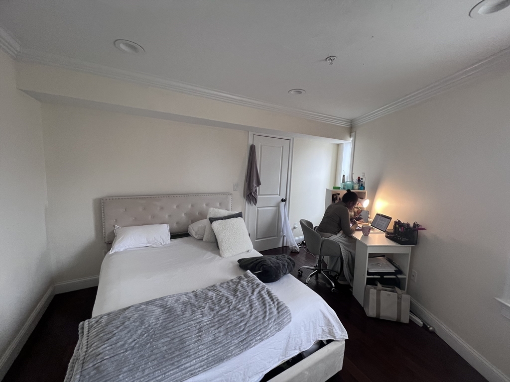 142 Centre Street, Unit 2 Boston, MA 02119 - Photo 6 of 9 a bedroom with a bed and wooden floor