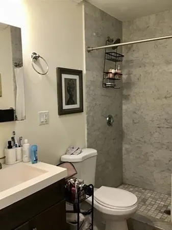 a bathroom with a sink mirror vanity and toilet