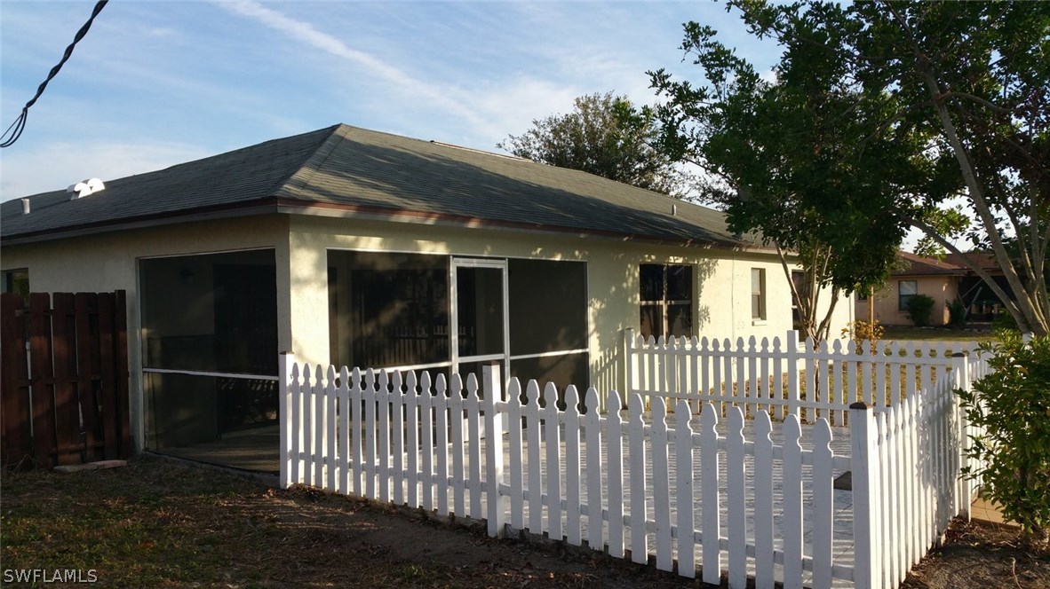 17476 Fuchsia Road Fort Myers, FL 33967 - Photo 3 of 16 a view of a house with a small yard and wooden fence