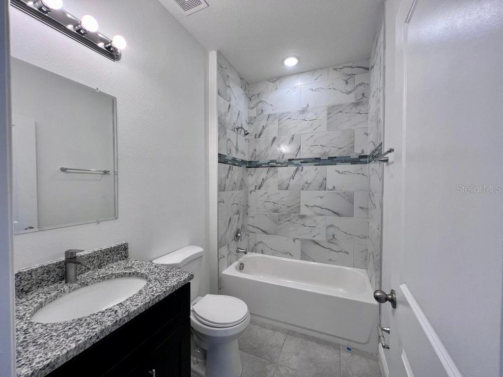 6325 Southwest 144th Lane Road Ocala, FL 34473 - Photo 10 of 31 a bathroom with a granite countertop sink toilet and shower