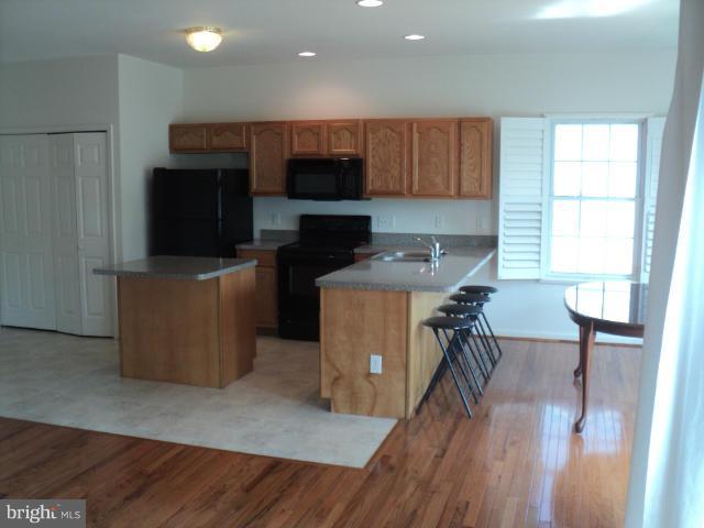 56 Peter Rabbit Drive Ranson, WV 25438 - Photo 10 of 28 a kitchen with a table chairs refrigerator and a window