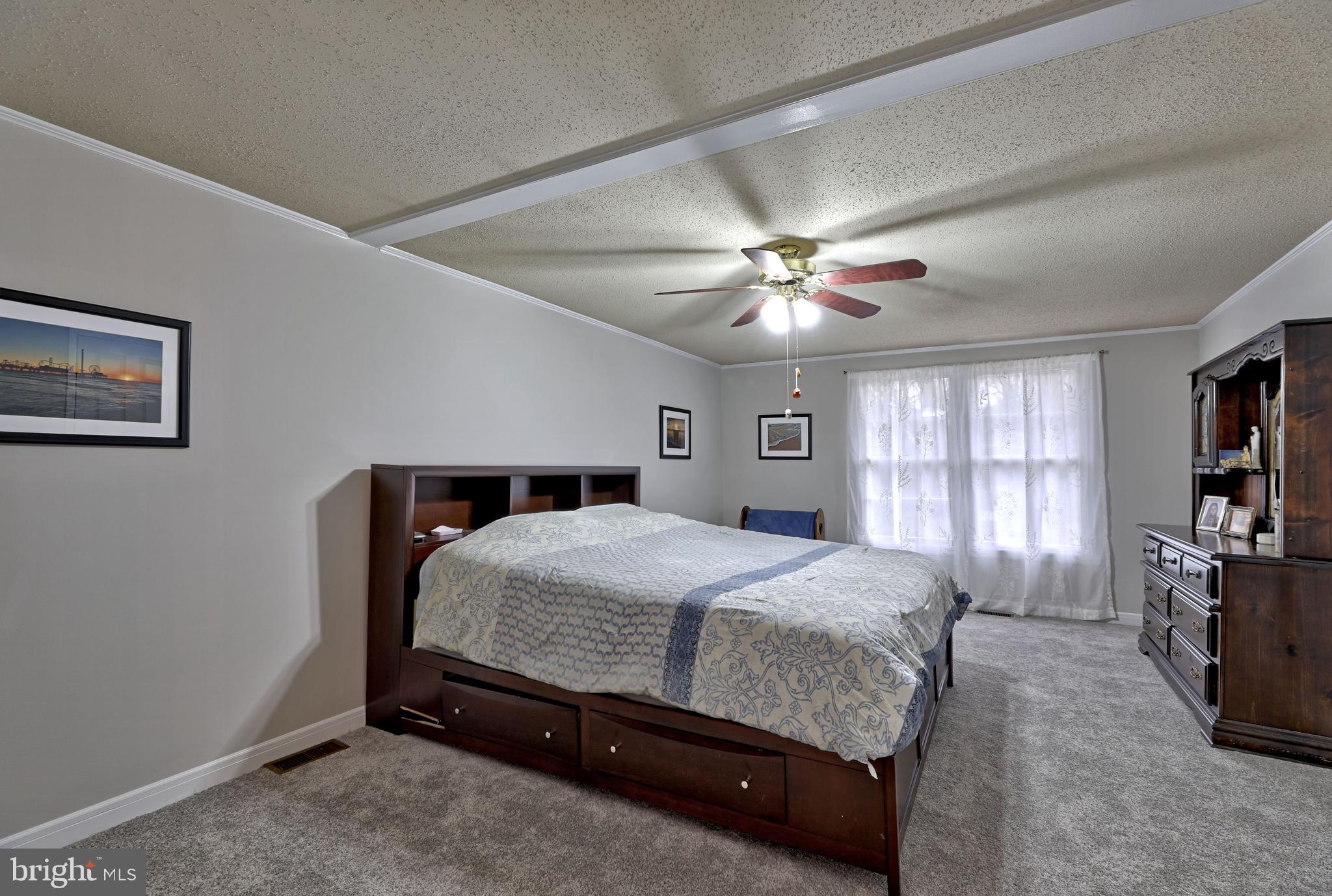 8 Meadow Drive Moorestown, NJ 08057 - Photo 22 of 36 a bedroom with a large bed a chandelier and flat screen tv