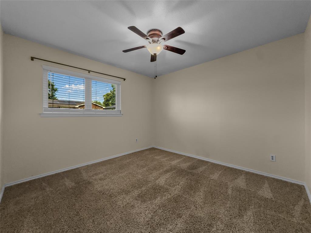220 Cooper Drive Hurst, TX 76053 - Photo 21 of 27 an empty room with window and ceiling fan