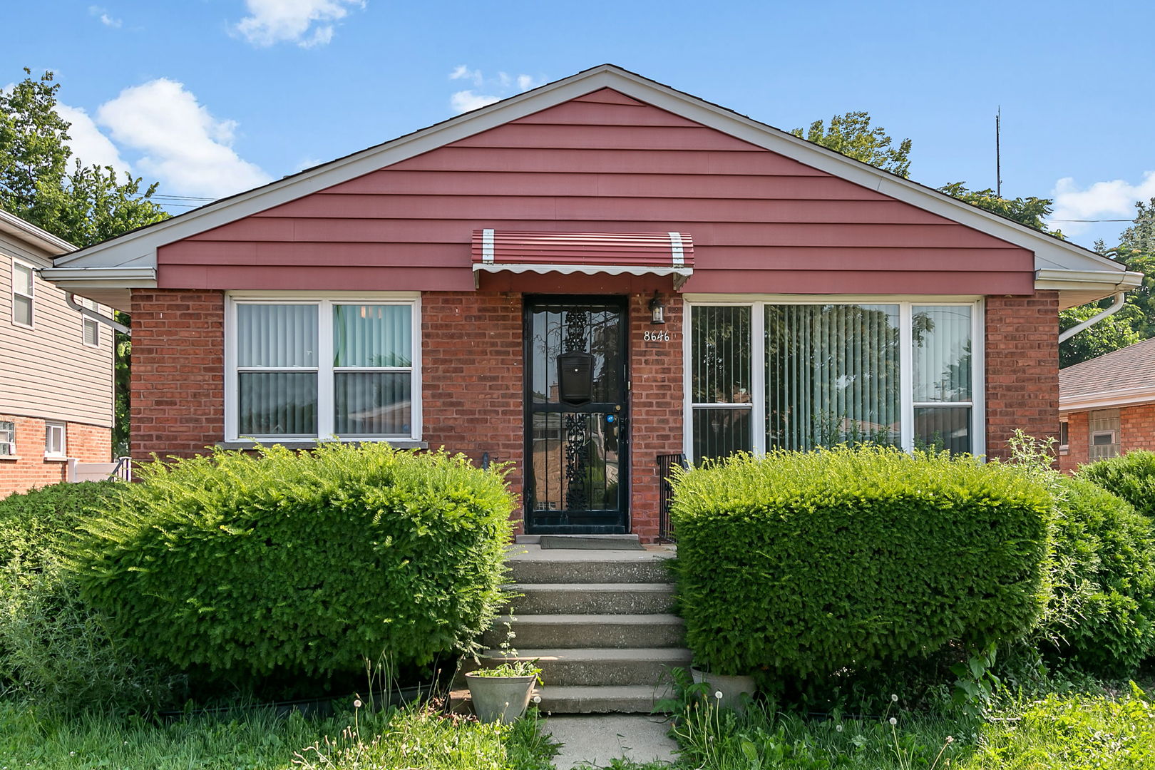 a view of a house with potted plants and a table and chairs