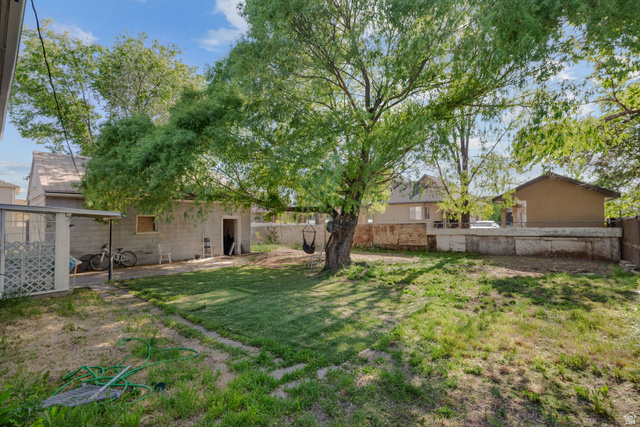 1275 North Geneva Road Provo, UT 84601 - Photo 24 of 25 Expansive yard featuring mature trees, a detached block structure, and a covered patio area