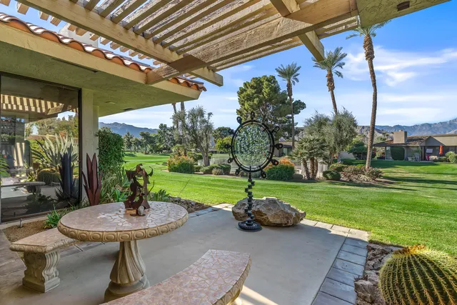 a view of a table and chairs in backyard of the house