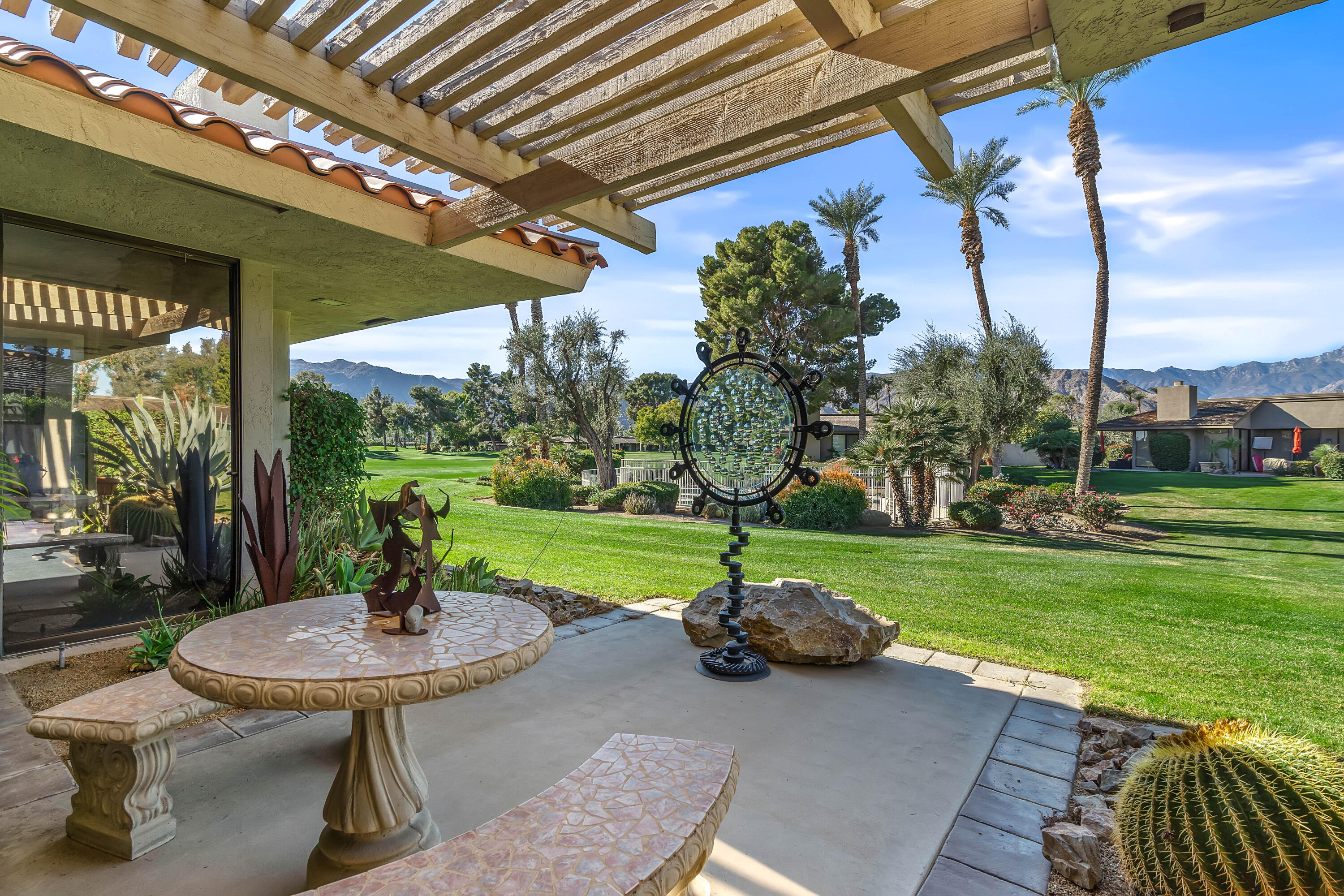 a view of a table and chairs in backyard of the house