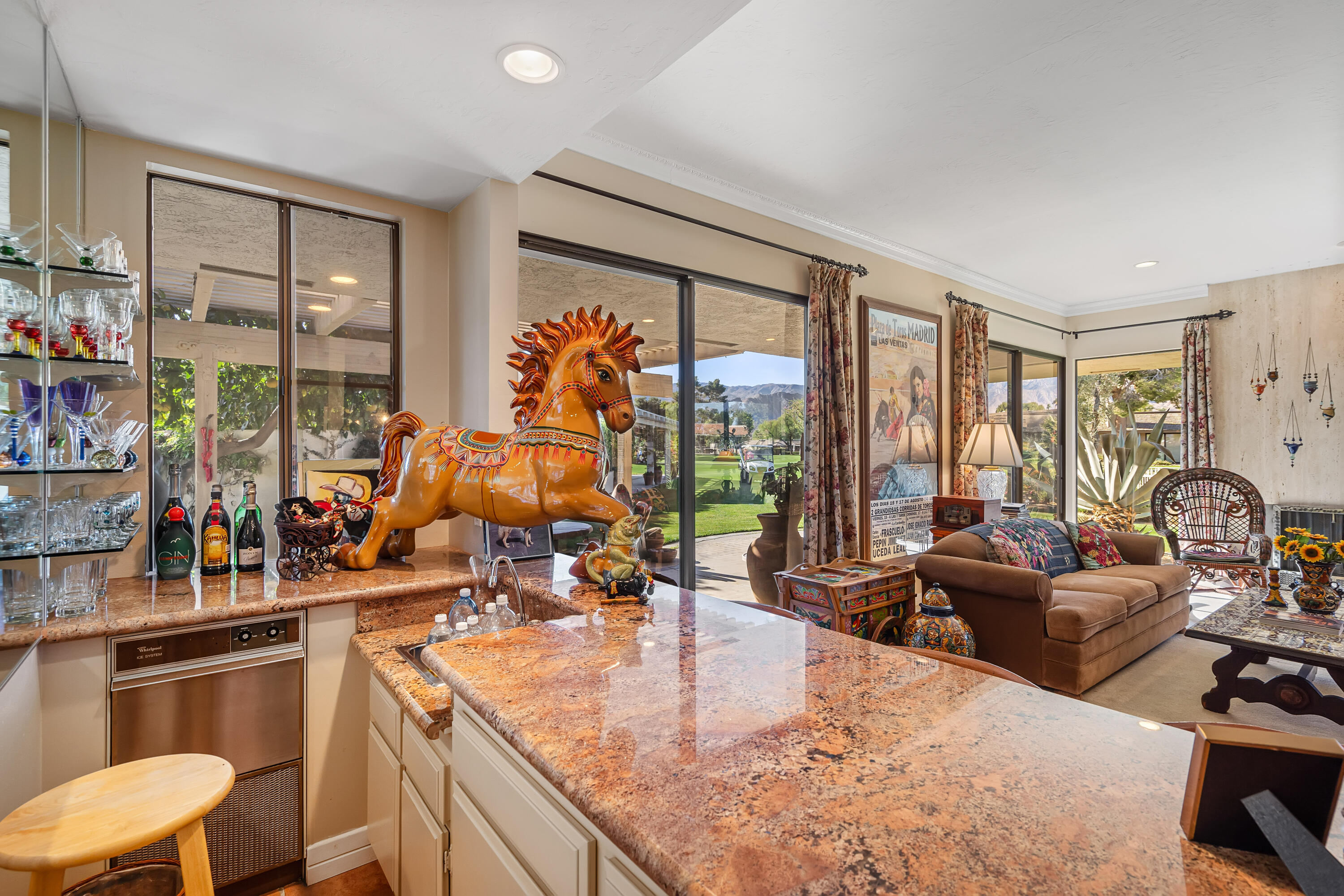 9 Swarthmore Court Rancho Mirage, CA 92270 - Photo 12 of 43 a kitchen with stainless steel appliances kitchen island granite countertop a stove and a view of living room