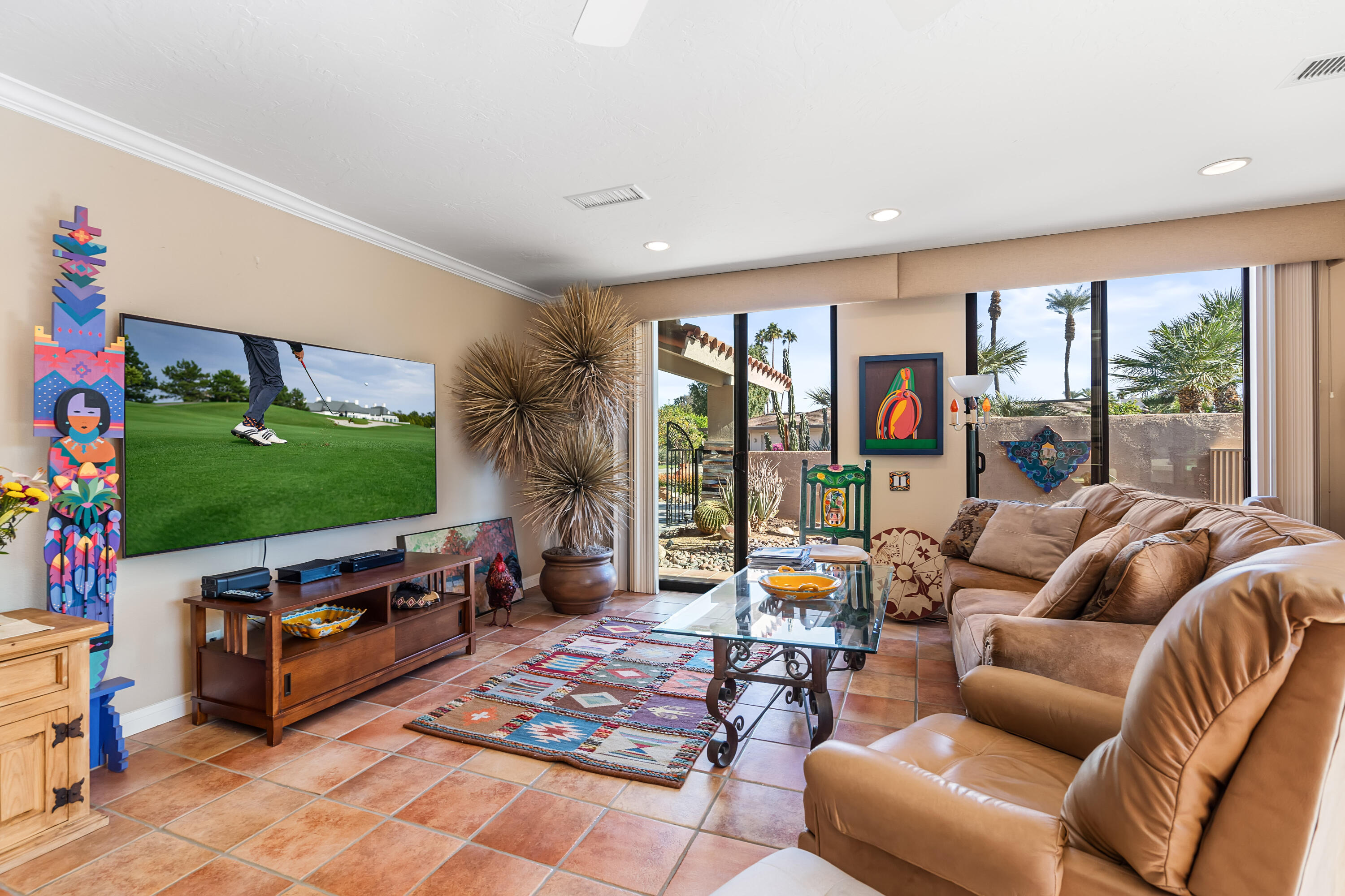 9 Swarthmore Court Rancho Mirage, CA 92270 - Photo 17 of 43 a living room with furniture a flat screen tv and a floor to ceiling window